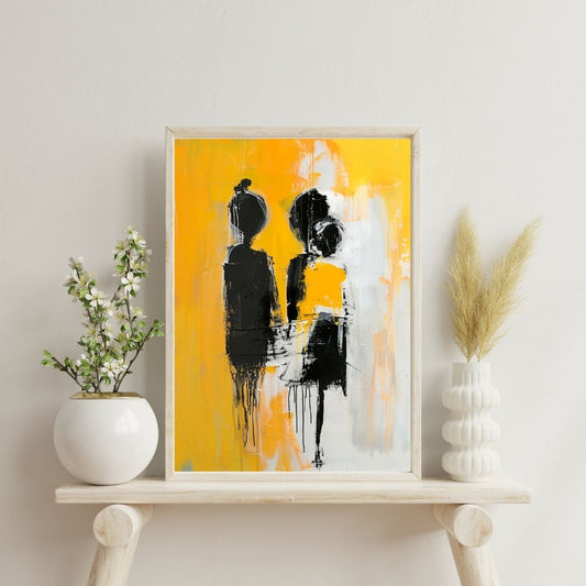 Framed abstract art with black and white figures on a yellow background, displayed on a shelf with decorative plants.