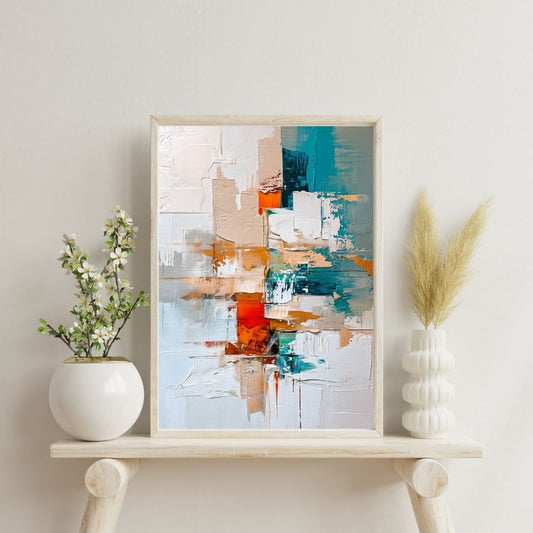 Framed abstract art piece on a shelf with decorative plants against a light wall.