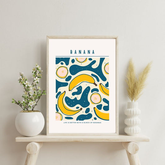 Framed artwork with banana design on a shelf with decorative items.