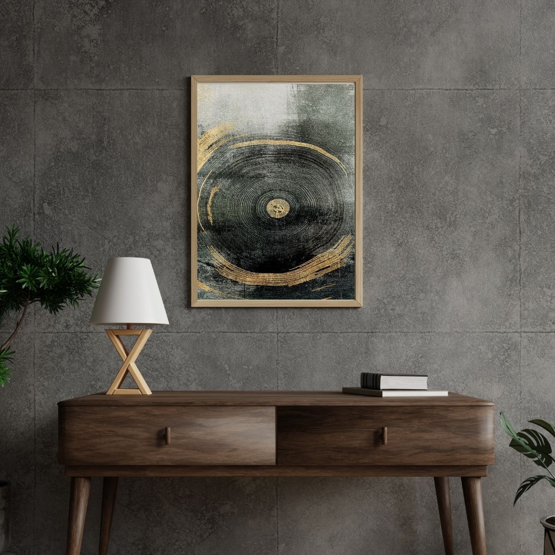 Framed abstract art on a gray wall above a wooden console table with a lamp and books.