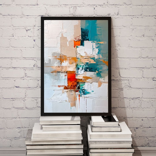 Abstract art print in a black frame on a stack of books against a white brick wall.