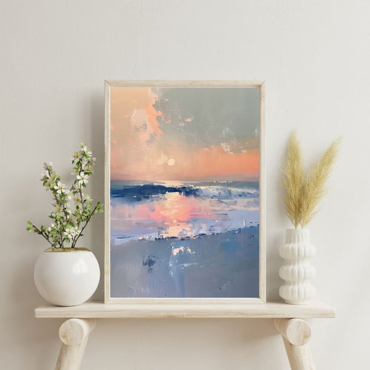 Framed artwork of a sunset over water on a shelf with decorative plants.
