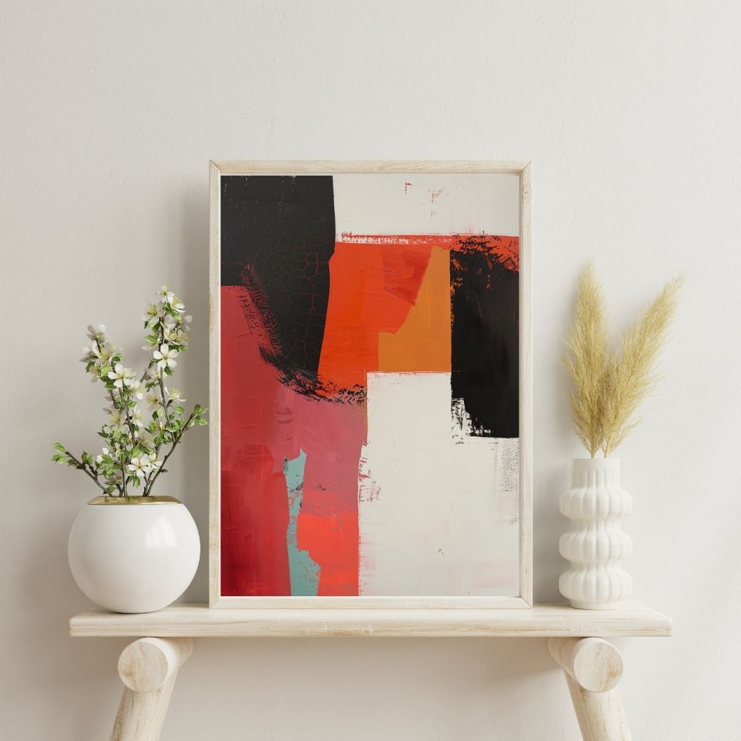 Framed abstract art piece on a shelf with decorative plants against a light wall.