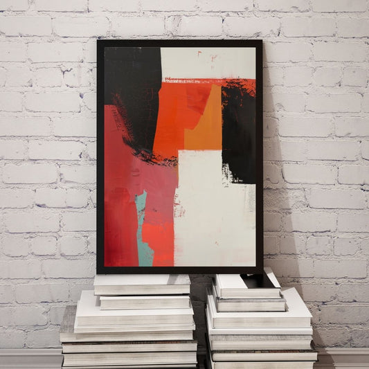 Abstract art print in a black frame on a stack of books against a white brick wall.