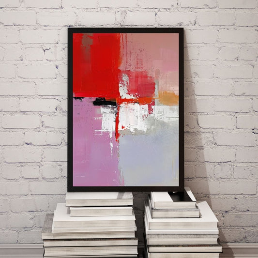 Abstract painting with red, pink, and white on a black frame against a white brick wall.