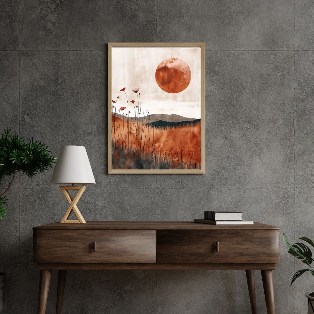 Framed abstract artwork with a sun and mountains on a gray wall above a wooden console table.
