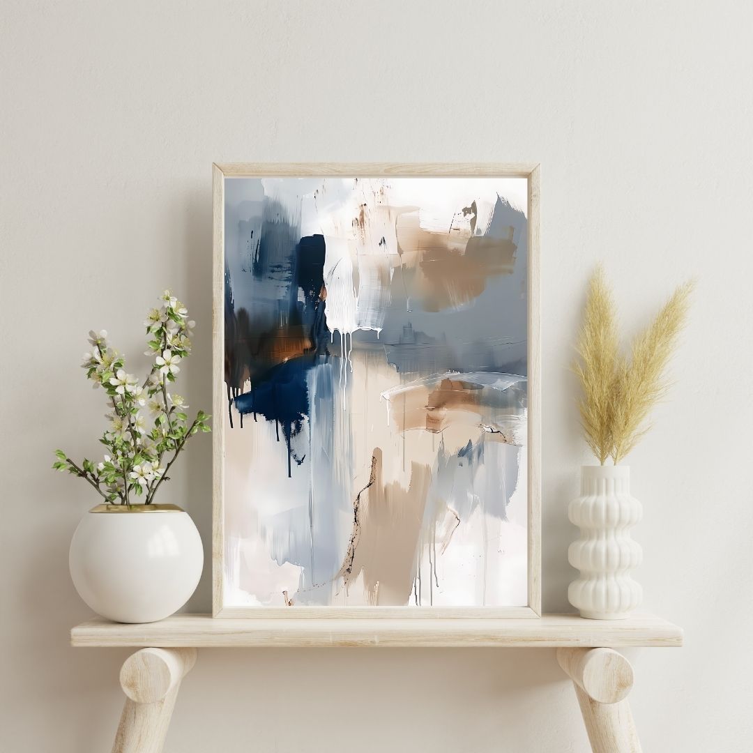 Framed abstract art piece on a shelf with decorative plants against a light wall.