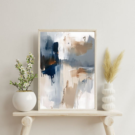 Framed abstract art piece on a shelf with decorative plants against a light wall.