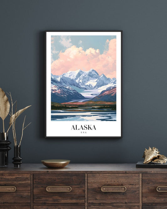 Framed poster of a mountain landscape with 'Alaska' text on a dark wall above a wooden cabinet.