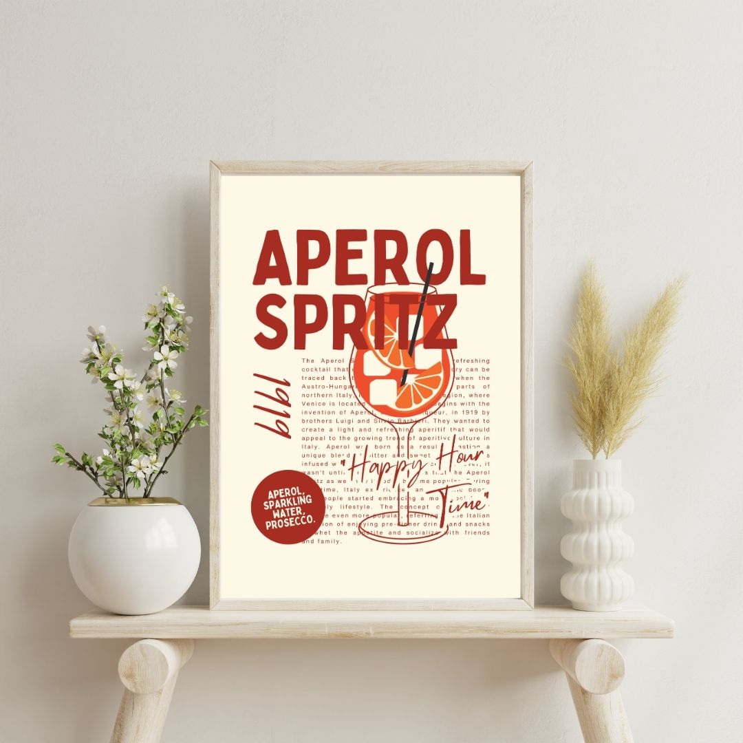 Framed Aperol Spritz recipe print on a shelf with decorative plants.