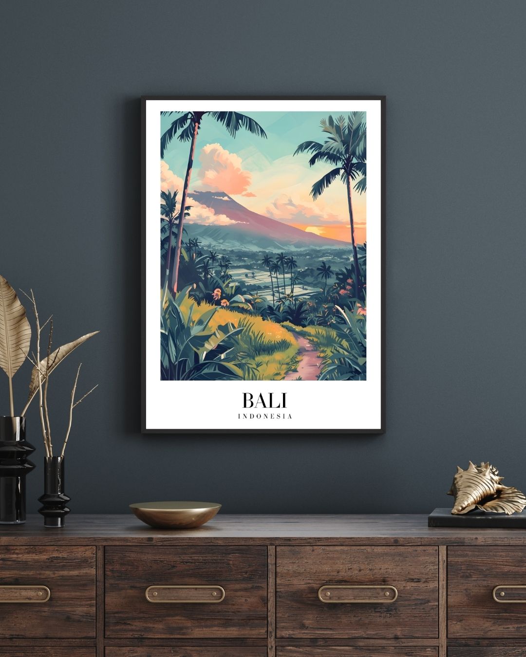 Framed artwork of Bali landscape on a dark wall above a wooden cabinet.