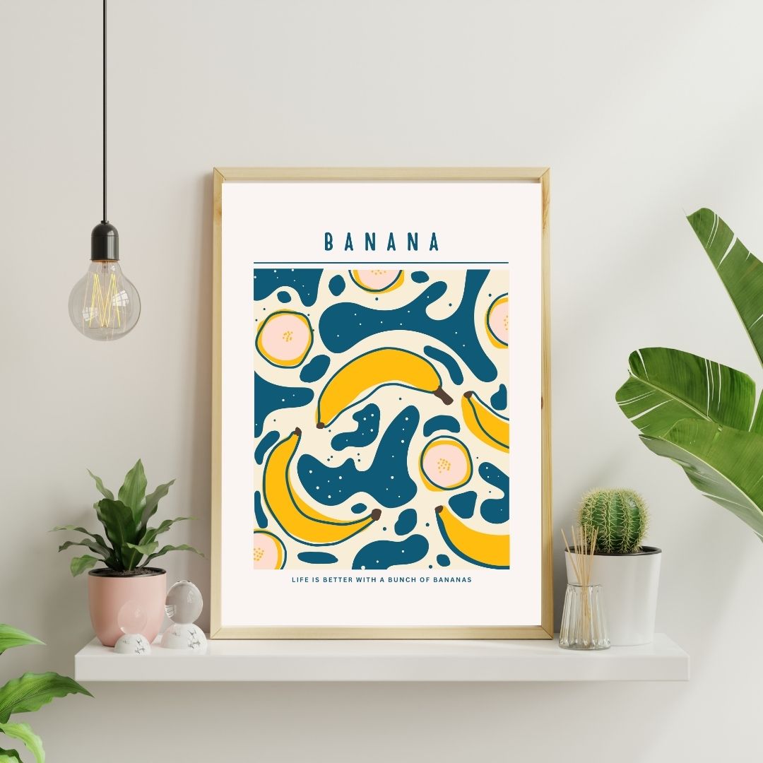 Framed artwork with banana design on a wall with plants and light fixture.