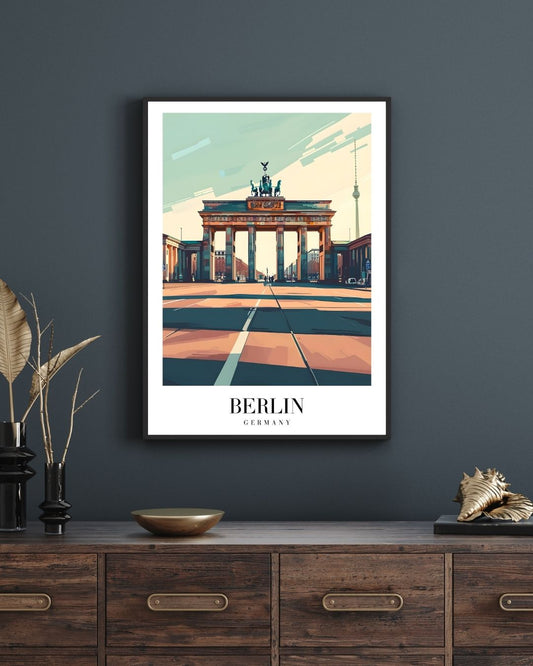 Framed poster of Berlin's Brandenburg Gate on a dark wall above a wooden cabinet.